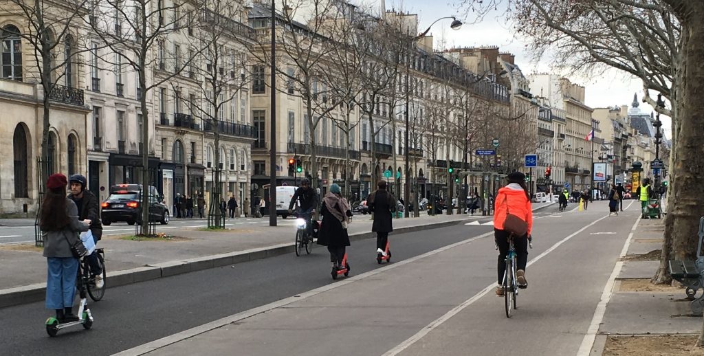 Cyclists, e-scotters users, pedestrians and cars along the Sein in Paris