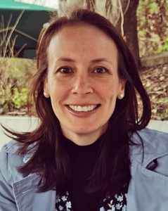 Dr. Therese Kenna, a white woman with long brown hair and brown eyes, smiling.