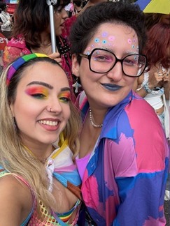 Two young women in brightly coloured clothes with their faces painted.