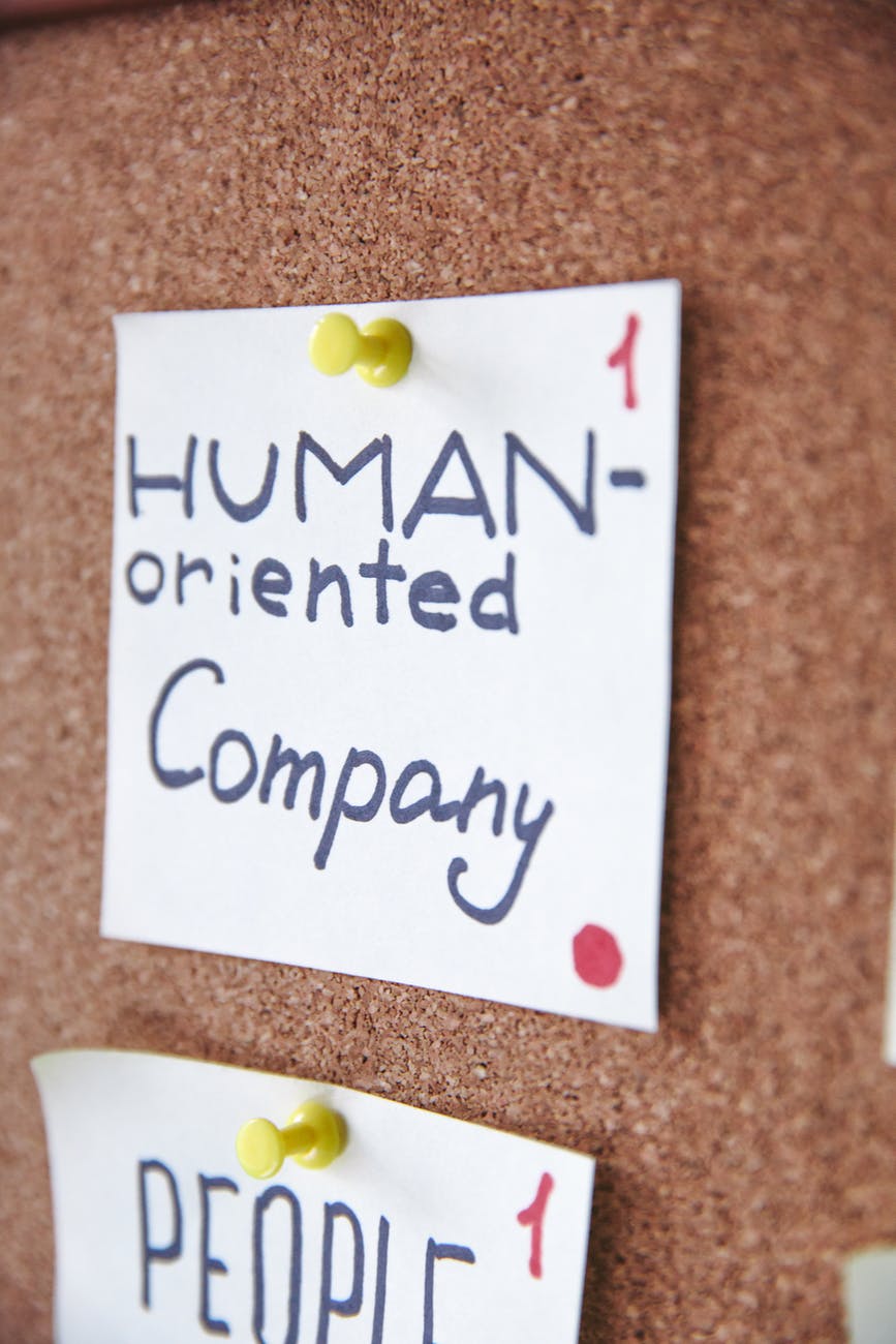 Sticky notes pinned to a wooden board that say 'Human oriented company'