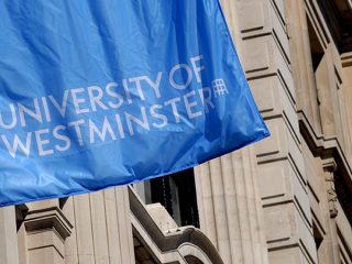 University of Westminster Flag (blue background, white lettering) flying on the side of a building