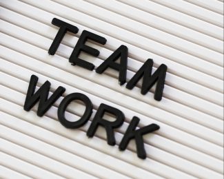 The words Team Work are spelt out in black letters on a white board