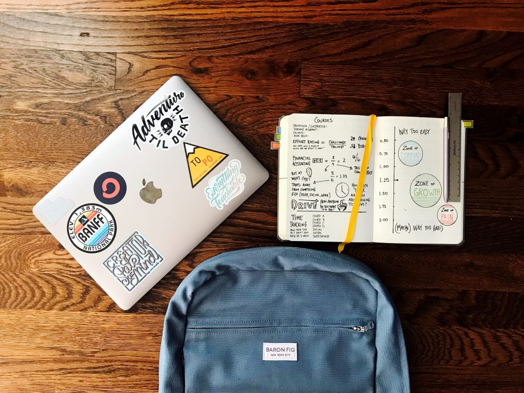 A laptop, notebook and a backpack 