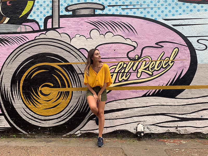 My Top 3 Tips for Exploring Shoreditch - International Student Blogger, Salome Mamasakhlisi - Salome leaning against a wall with Shoreditch street-art