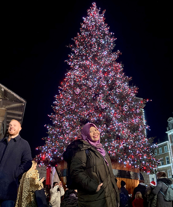 Budget Tips for Students Living in London_Lynn Zulkarim next to an outdoor Christmas tree at night _600x718