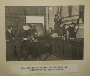 Black and white photograph of men working on electrics