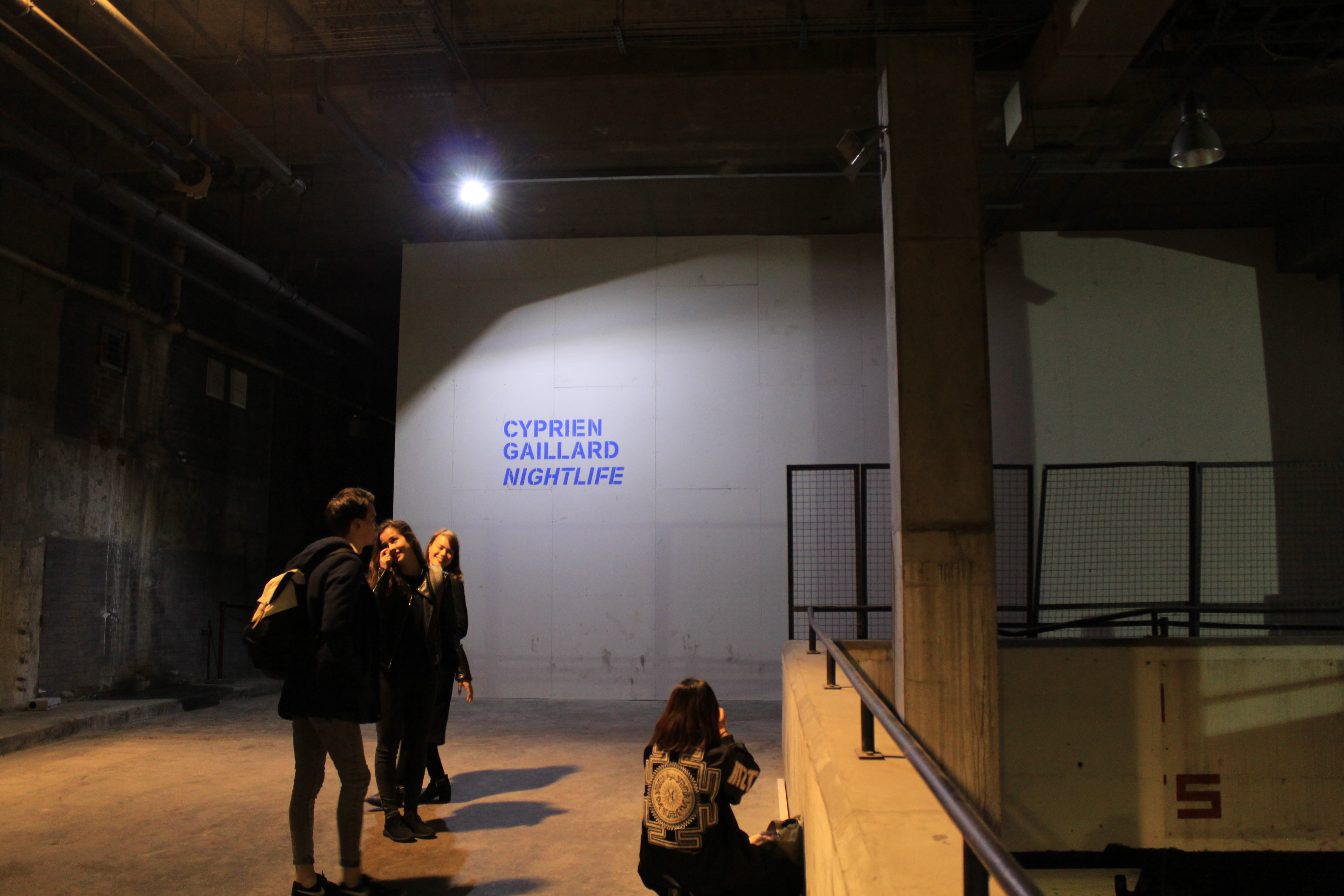 People making their way to Cyprien Gaillard's Nightlife situated in the building's carpark by Chloe Chapman