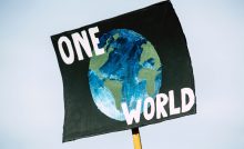 Protest poster with a painted image of earth, overlaid with text that states, "One Earth".