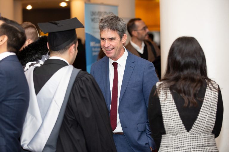 Student at graduation shaking the Vice Chancellors hand