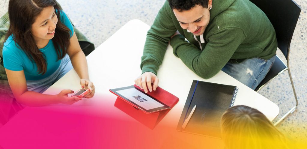 Group of students sitting round a laptop talking