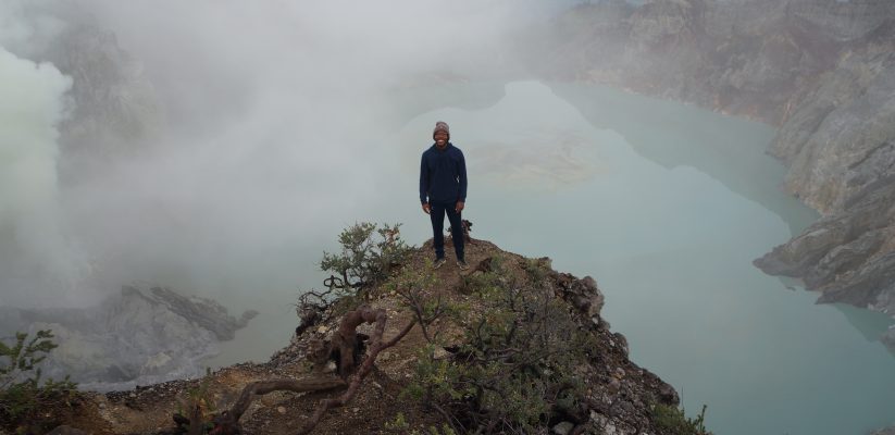 Photo of Michael at the top of a mountain in Java standing above a sulfuric lake