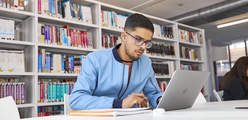 Student studying at laptop in library