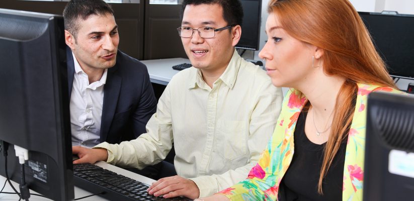 Postgraduate students sitting at a computer