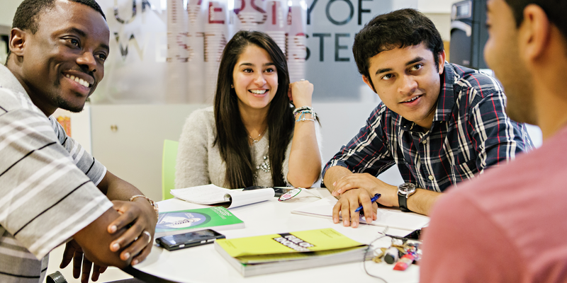 Students sat around a table filling out an application