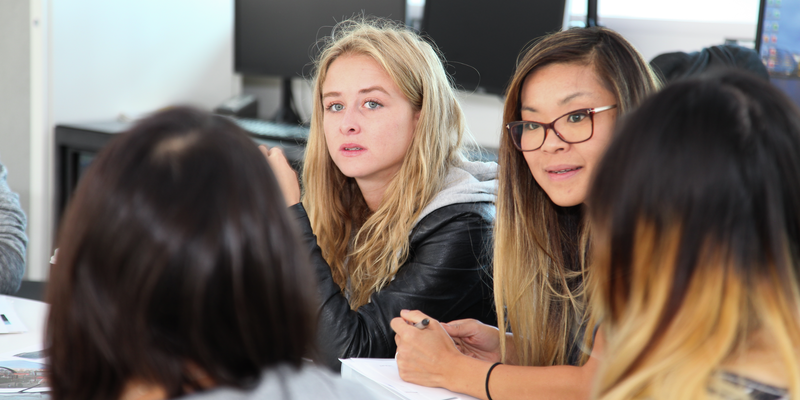 Students sat around a table discussing work