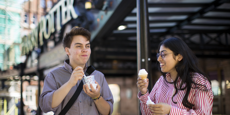 Male and female student eating ice cream outside of BoxPark