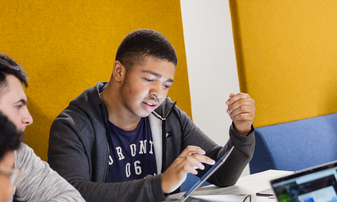 male-student-pointing-to-tablet-screen