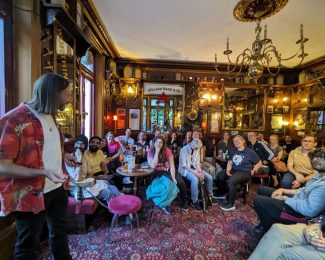 Dan Brayson mid talk on why Greenland Sharks live so long, to a room of people listening