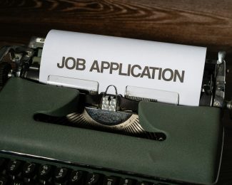 A typewriter with a sheet of paper titled job application