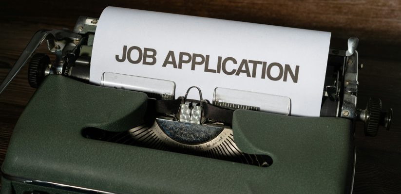 A typewriter with a sheet of paper titled job application