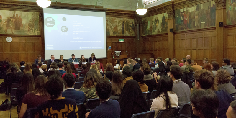 A panel of 5 people addressing and audience of interested attendees