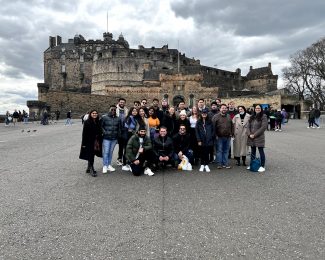 Group photo with Entrepreneurship students and staff with Edinburgh Castle in the background grey overcast sky